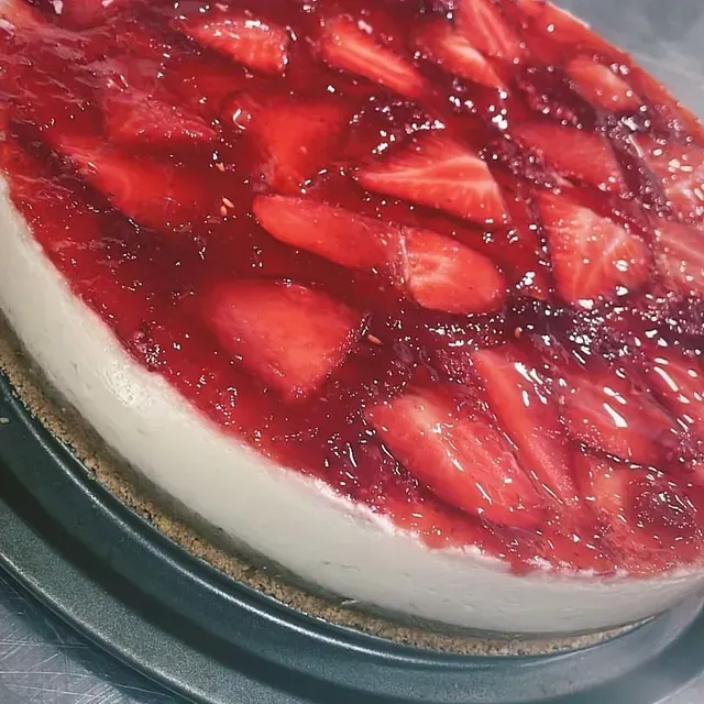 Una tarta de queso con fresas encima