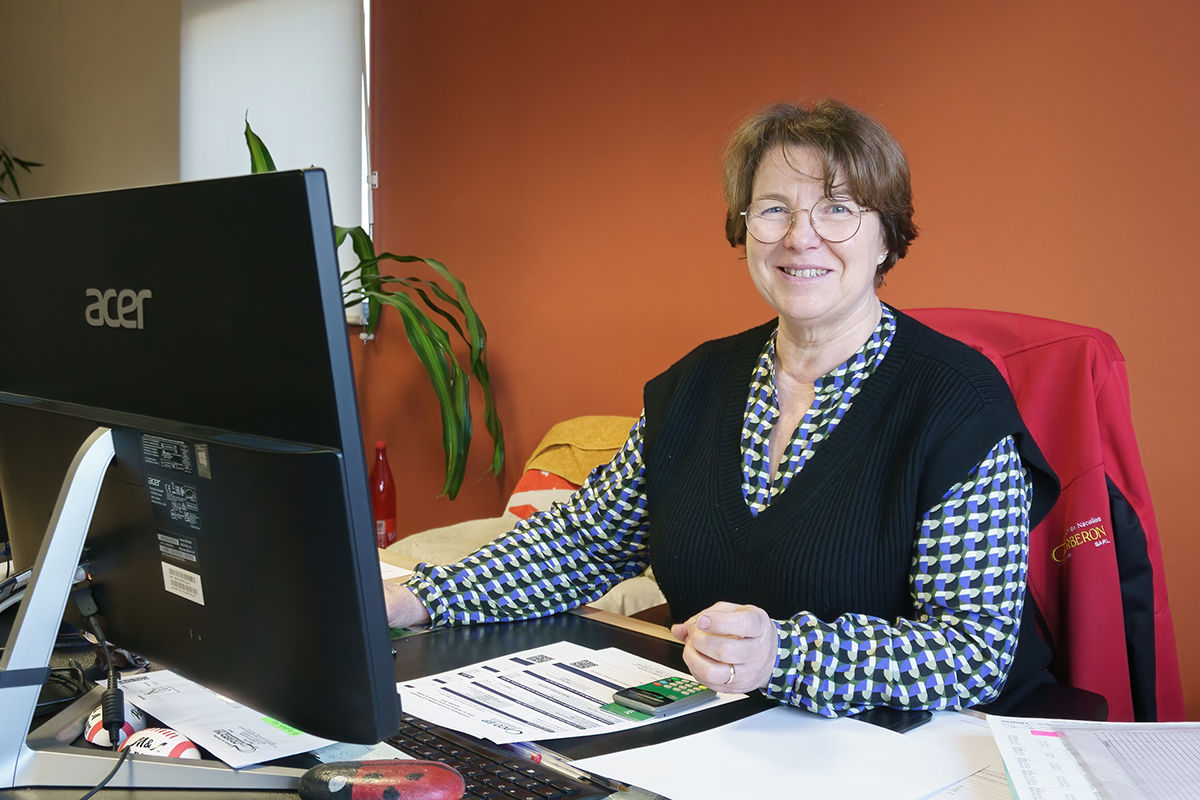 Employée souriante de Corberon Pierre assise à un bureau