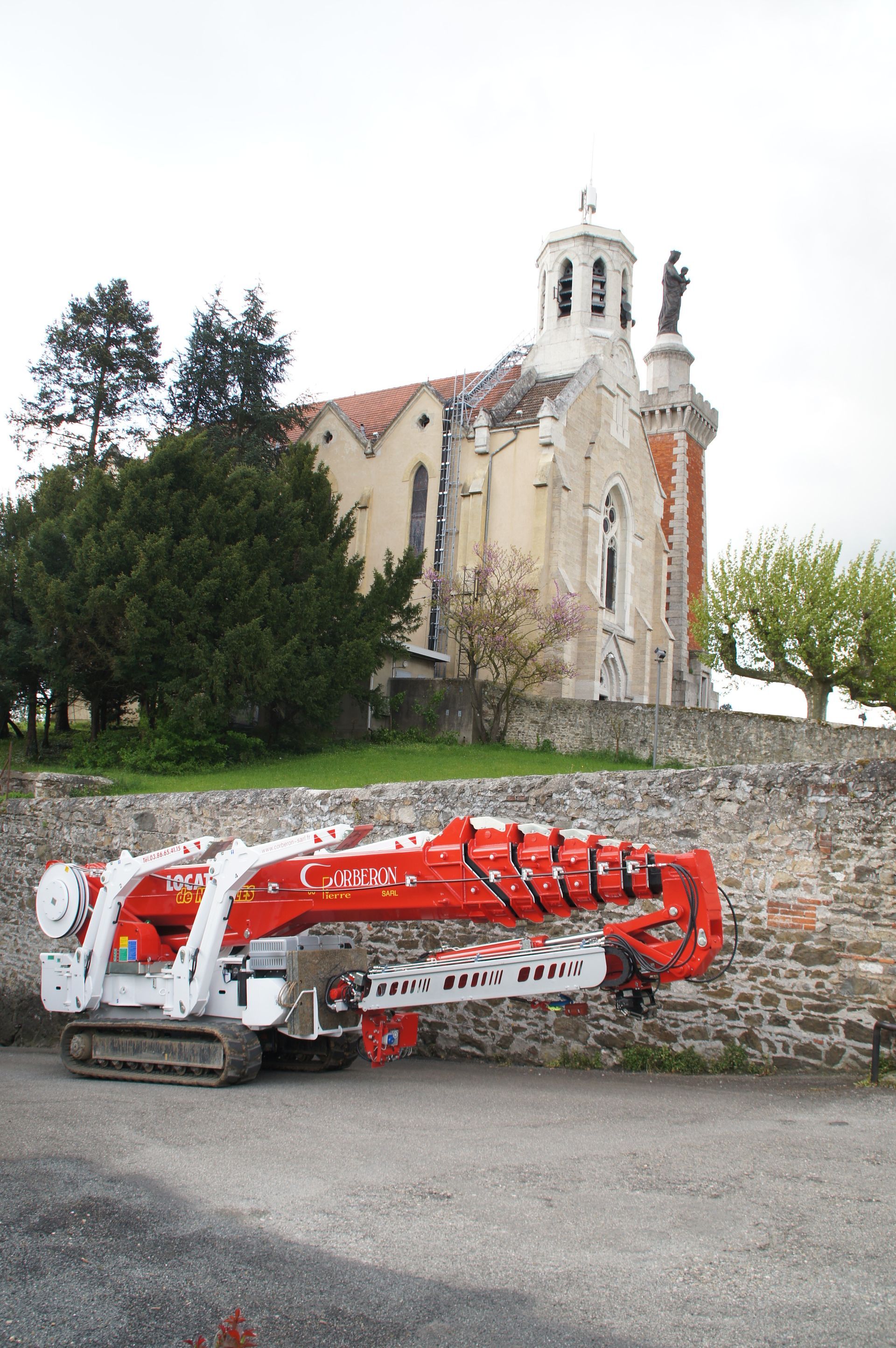 Nacelle-araignée rétractée devant une église