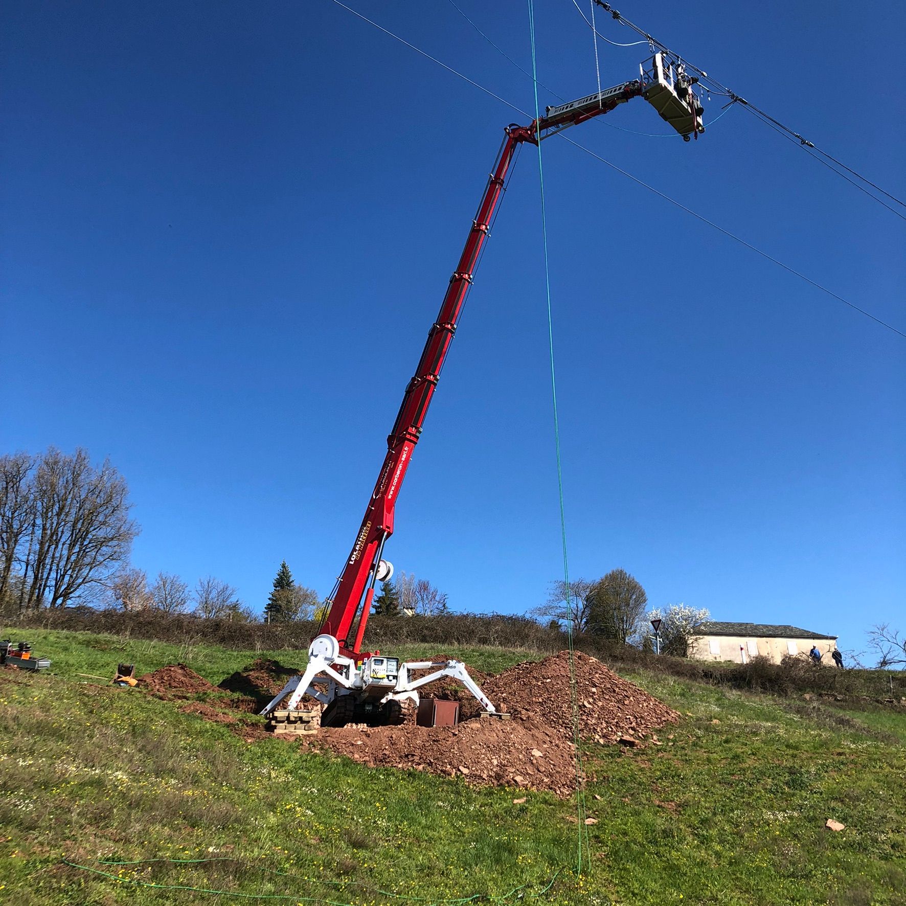 Nacelle-araignée déployée au niveau d'un câble électrique en pleine campagne