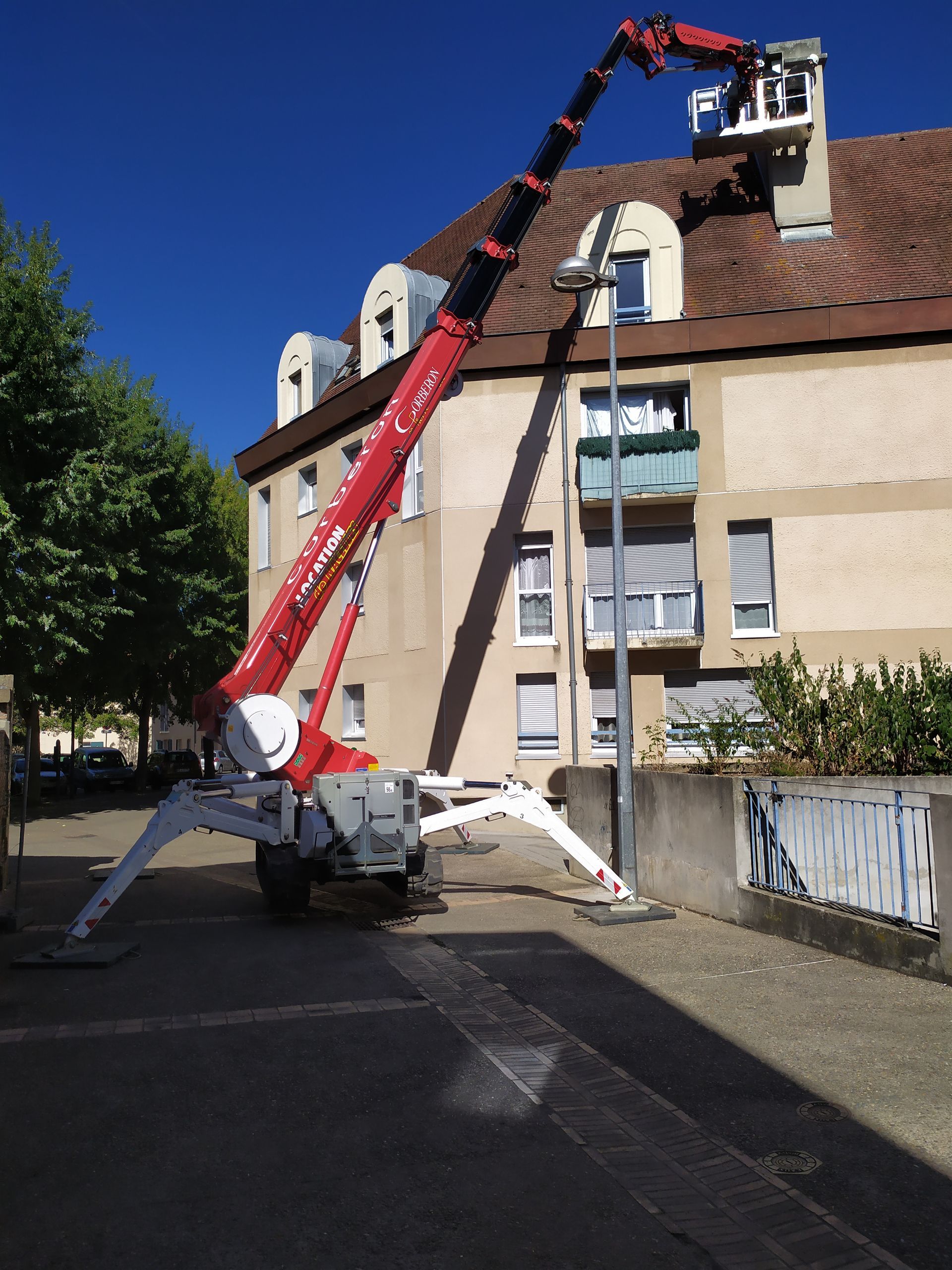Nacelle-araignée atteignant le haut d'une cheminée d'un bâtiment à trois étages
