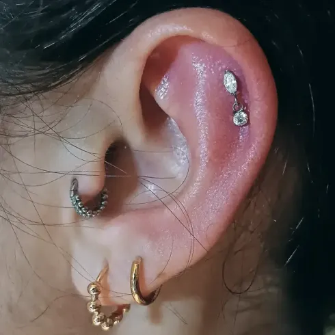 Oreja con múltiples perforaciones; son visibles las perforaciones en el hélix y el lóbulo.