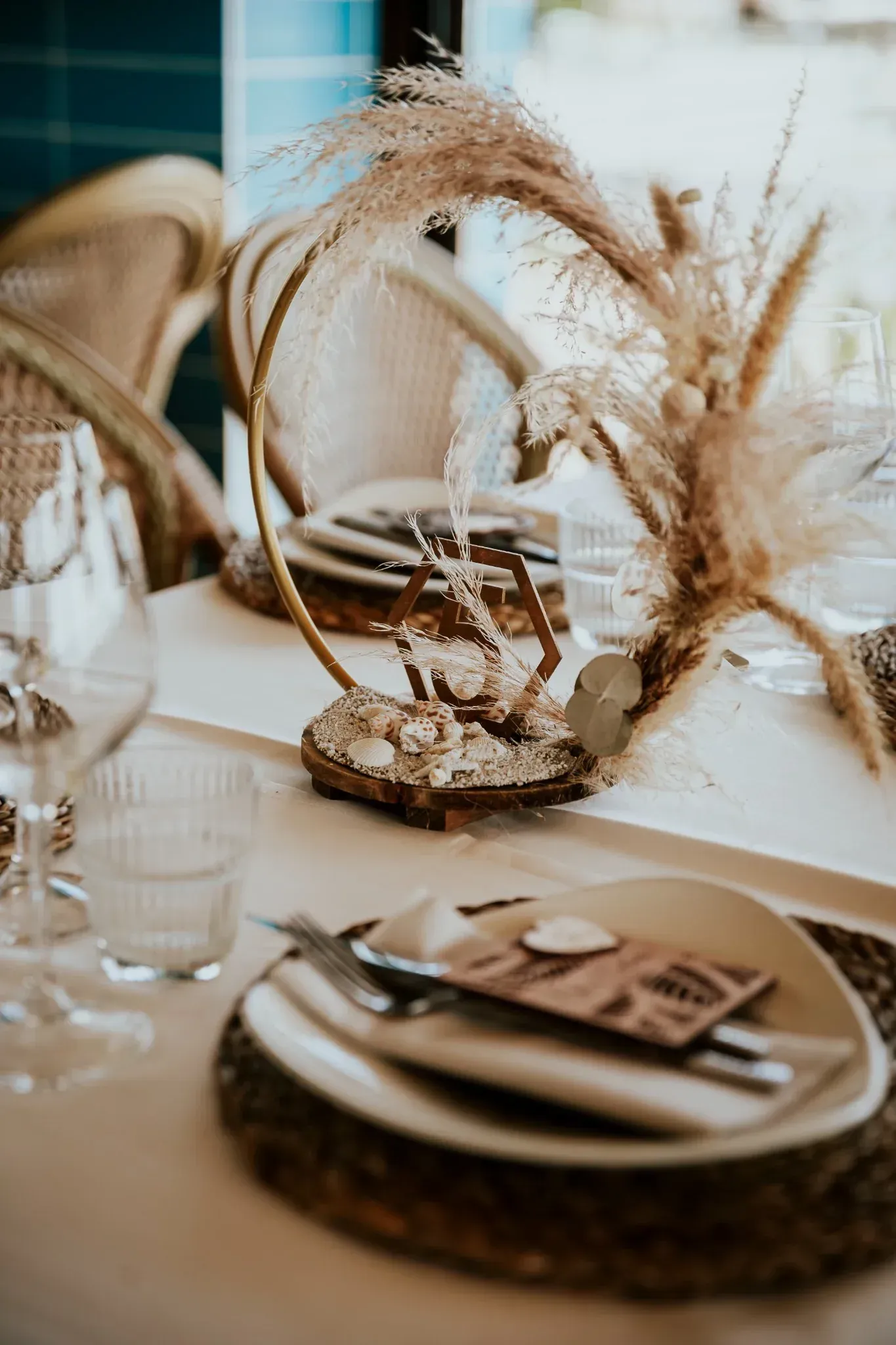 Elegante mesa decorada con hierbas secas y tonos neutros, para una boda.