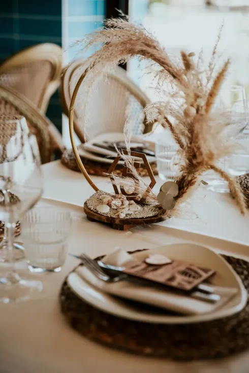 Elegante mesa decorada con hierbas secas y tonos neutros, para una boda.