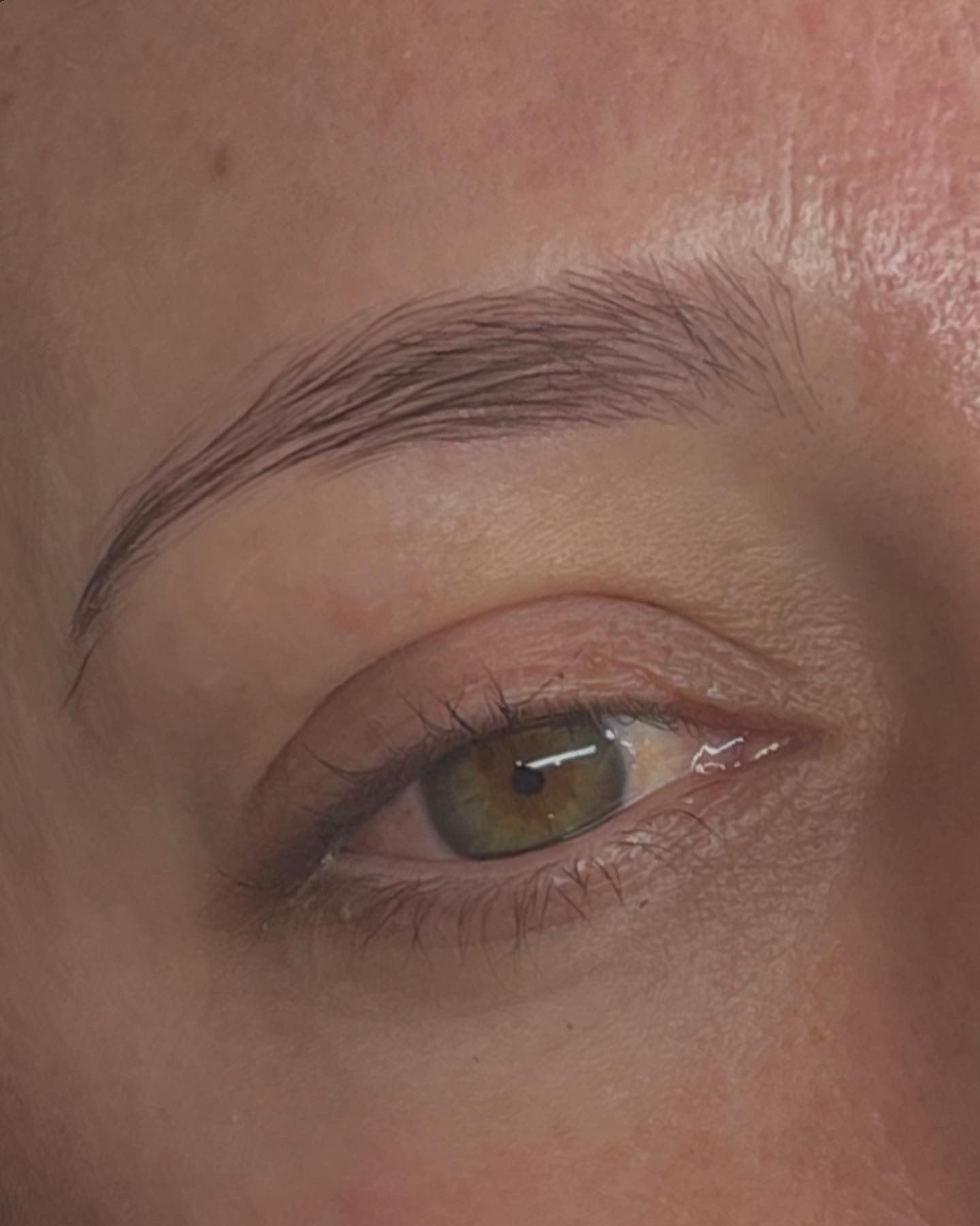 Un primer plano del ojo de una mujer con una pupila verde.