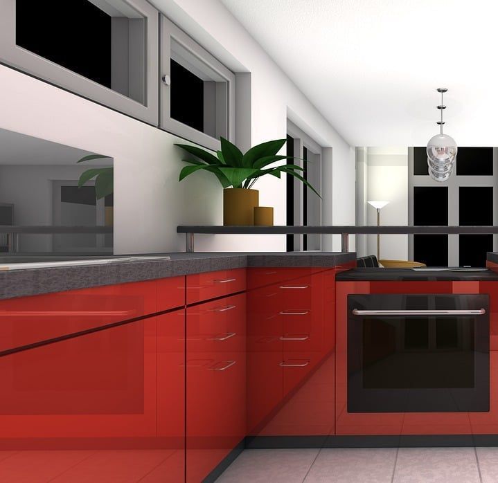 Una cocina con gabinetes rojos y un horno negro.