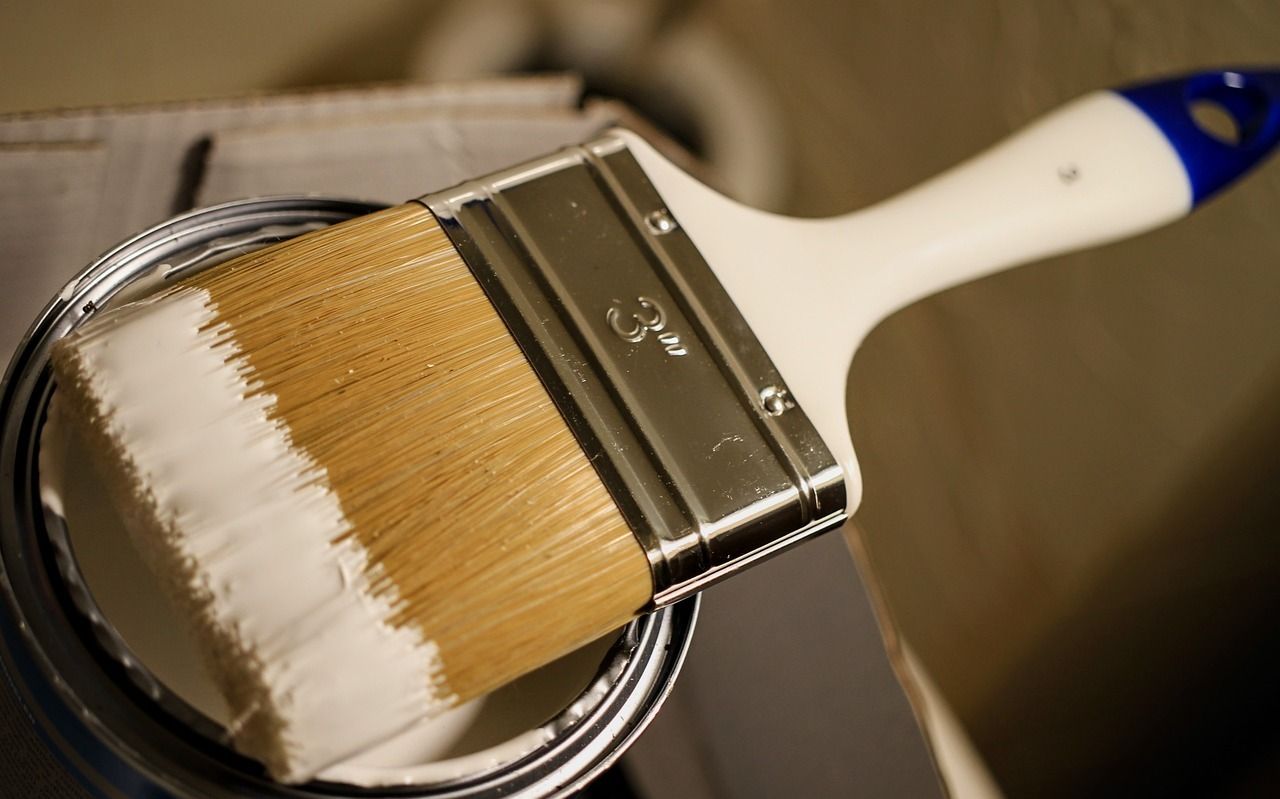 Un pincel está encima de una lata de pintura.