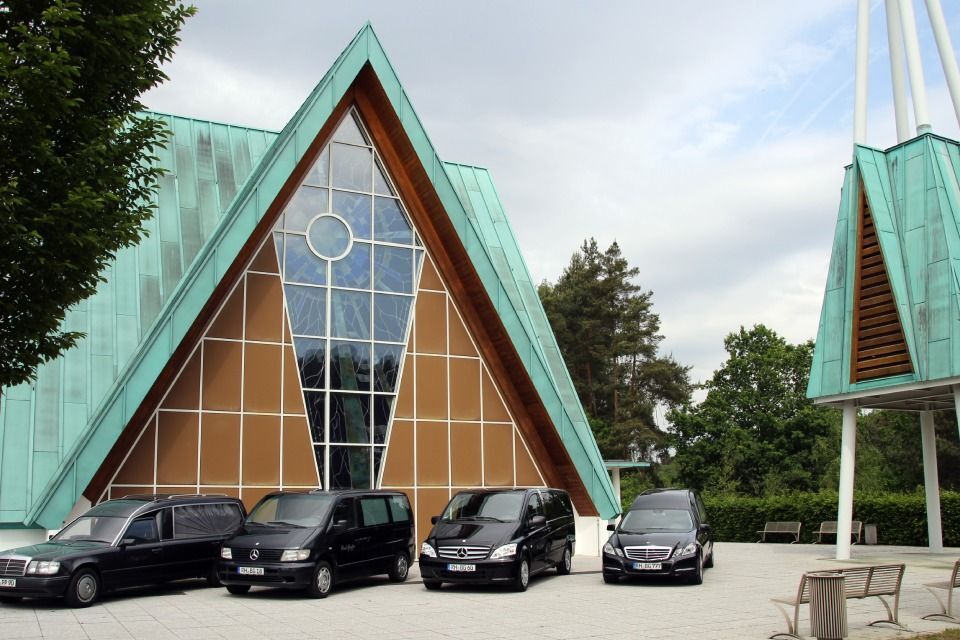 Wagen von Bestattungs - Institut Gruber vor einer Kirche