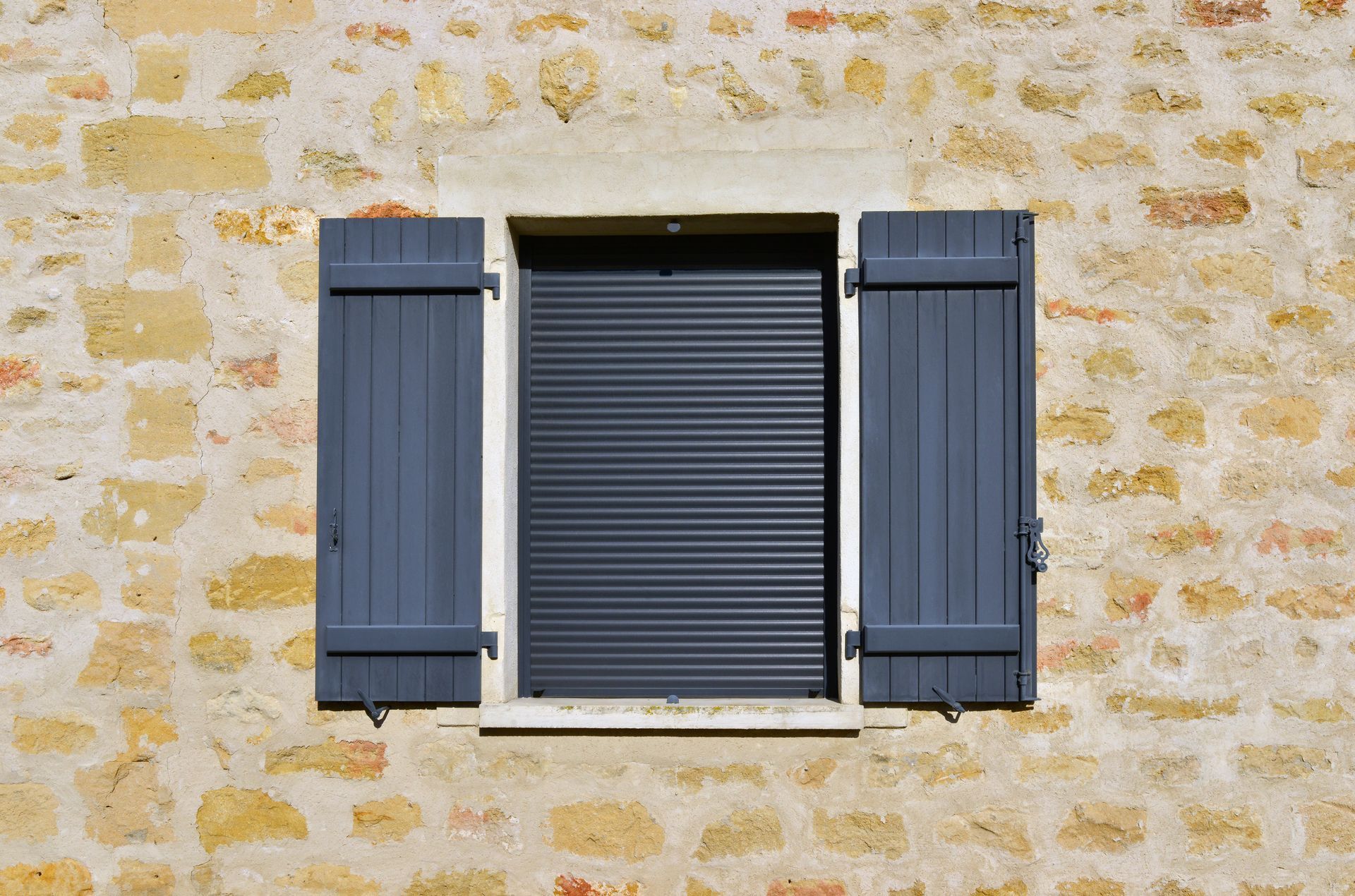 Volets roulants en aluminium sur une maison en pierres