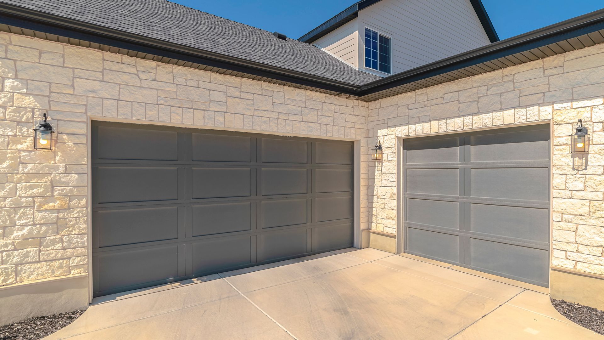Porte de garage en aluminium sur une belle maison en pierres
