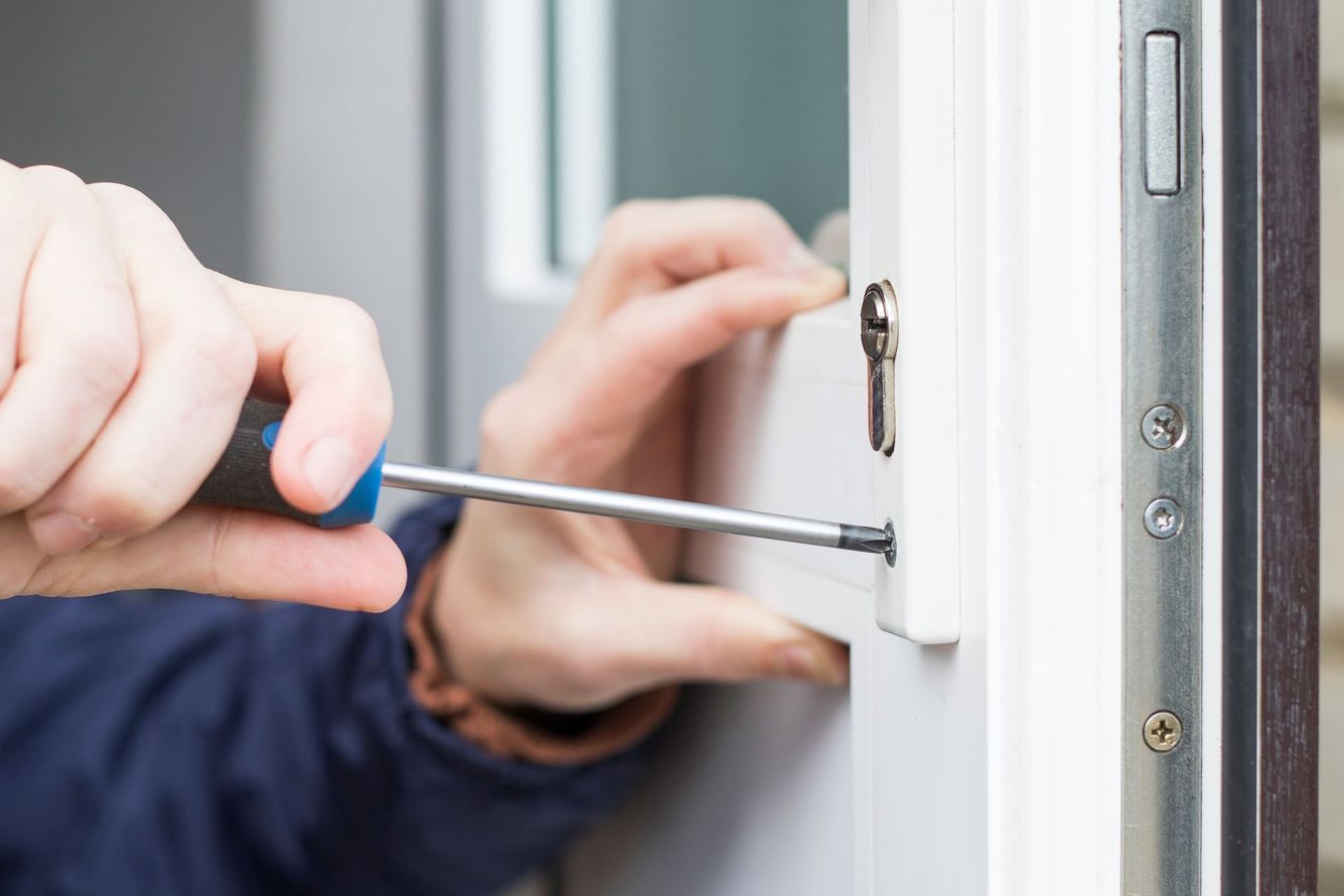 Réparation d'une serrure de porte d'entrée en PVC avec un tournevis