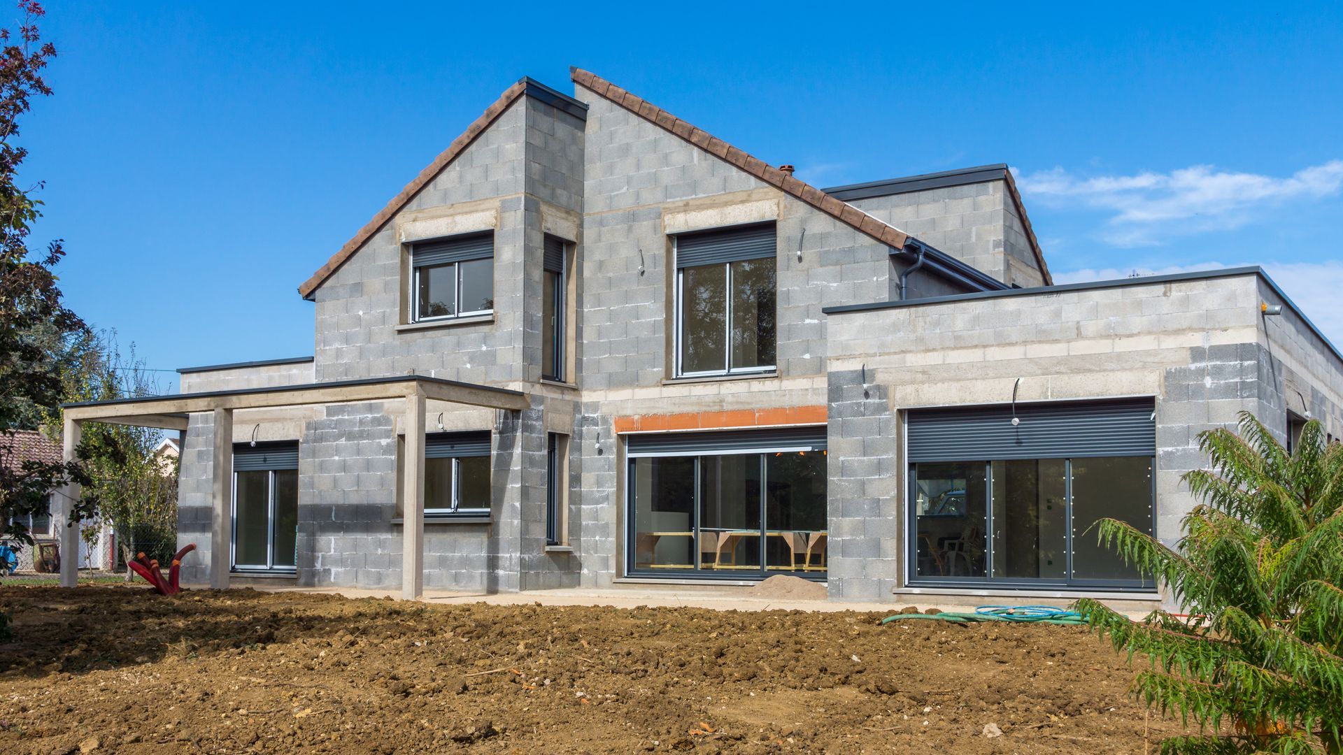 Chantier d'une maison neuve avec beaucoup de fenêtres et volets roulants