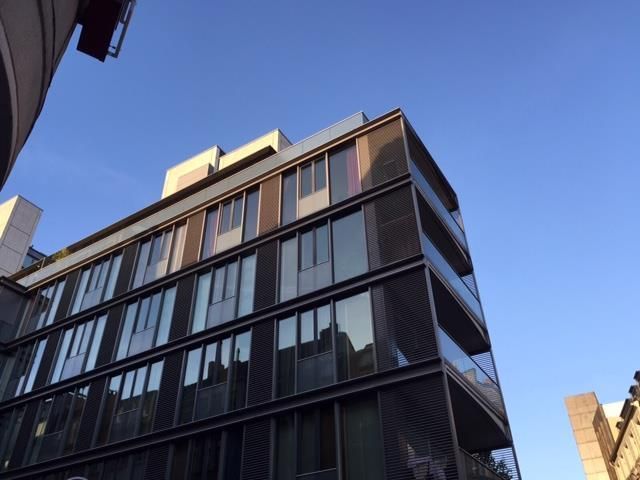 Modernes mehrstöckiges Gebäude vor blauem Himmel.