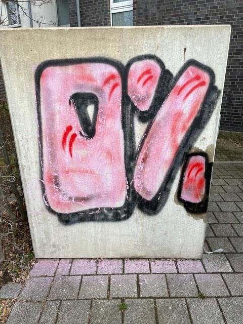 Graffiti „0 %“ in Pink mit schwarzem Umriss auf Betonwand.