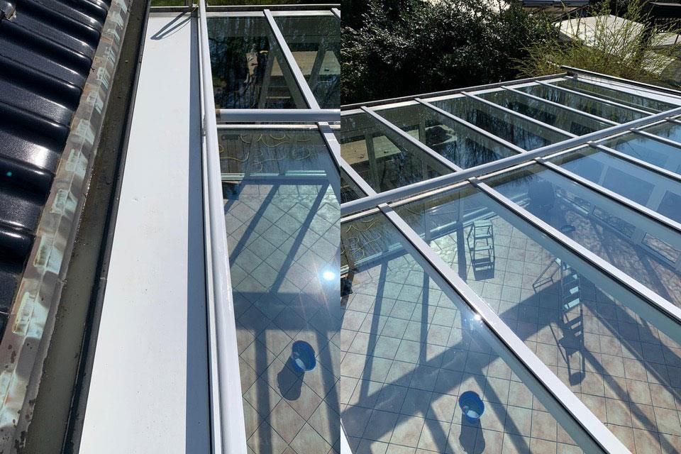 Abschnitte einer glasüberdachten Struktur mit einer sauberen weißen Dachrinne im Gegensatz zu einer schmutzigen, dunklen.