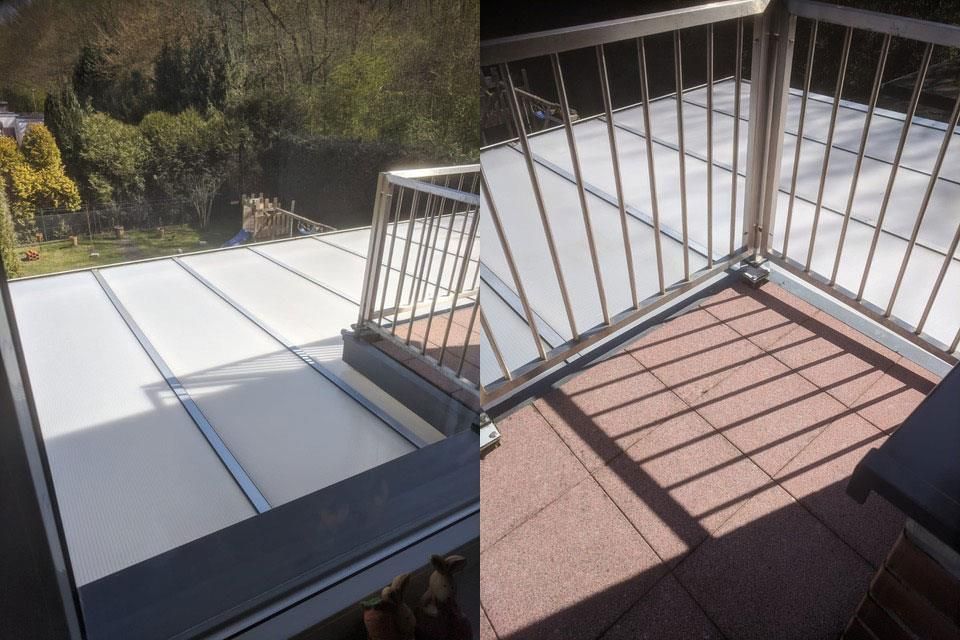 Balkon mit weißem Dach und Metallgeländer mit Blick ins Grüne.