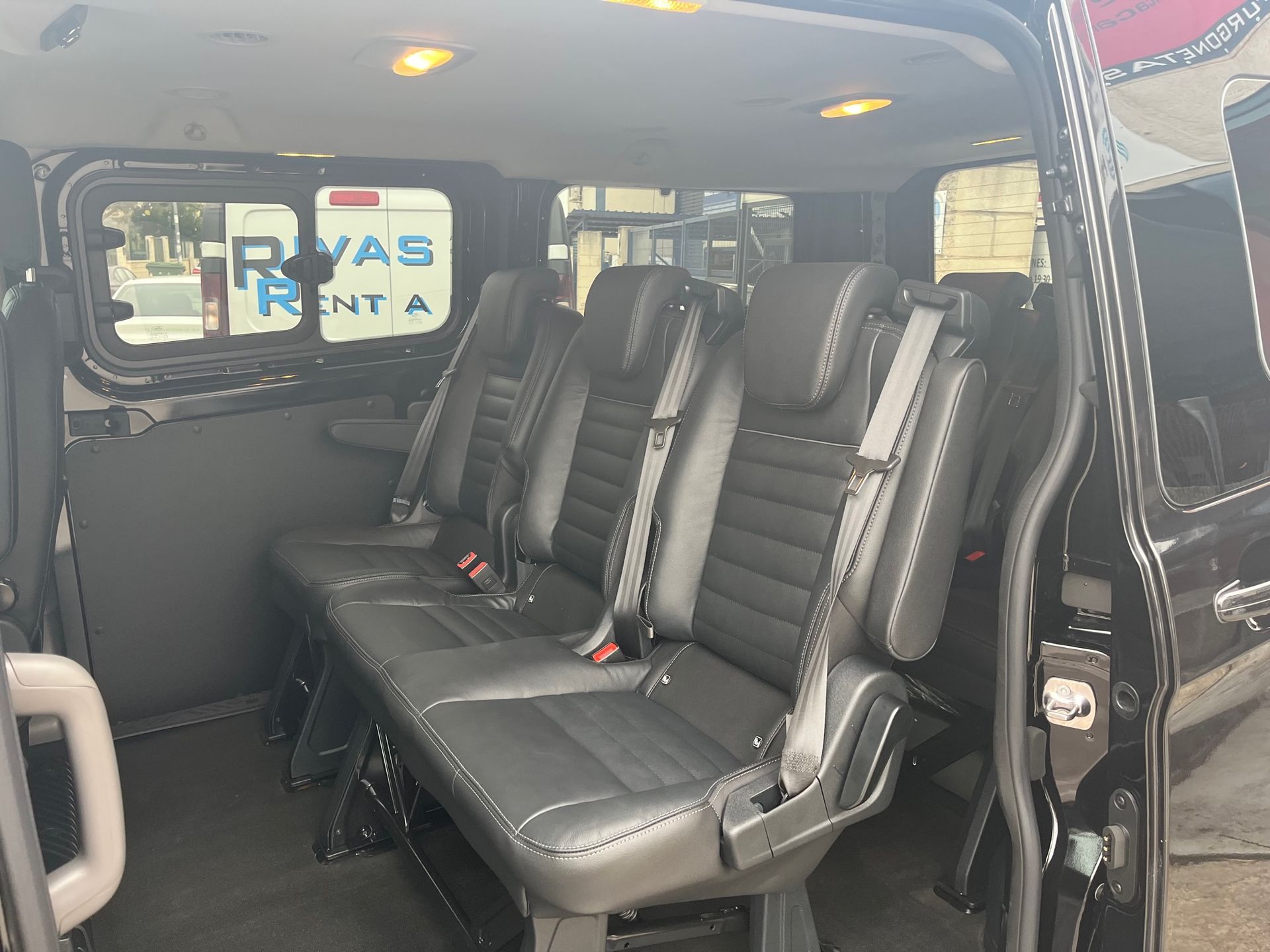 Una camioneta negra está estacionada frente a un edificio.