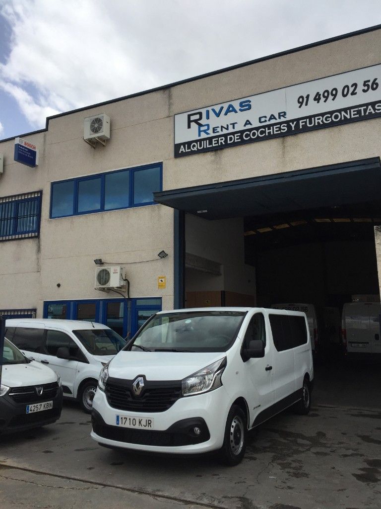 Dos furgonetas blancas están estacionadas una al lado de la otra al costado de la carretera.