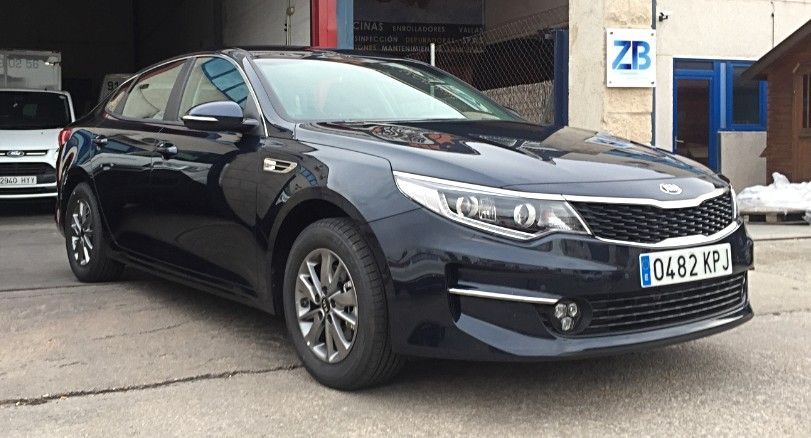 Un coche negro está aparcado delante de un edificio.