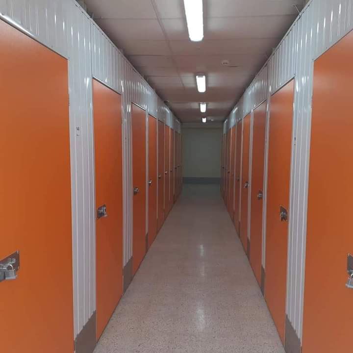 Un largo pasillo con puertas naranjas en un edificio.