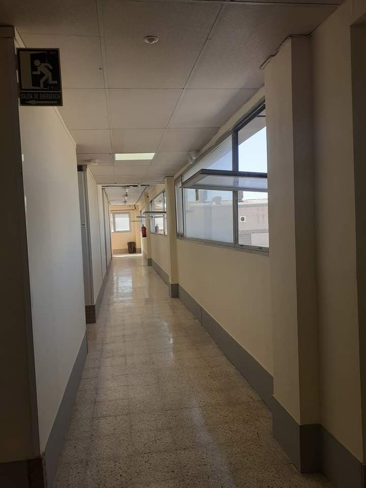 Un largo pasillo con un cartel en la pared que dice evacuación.