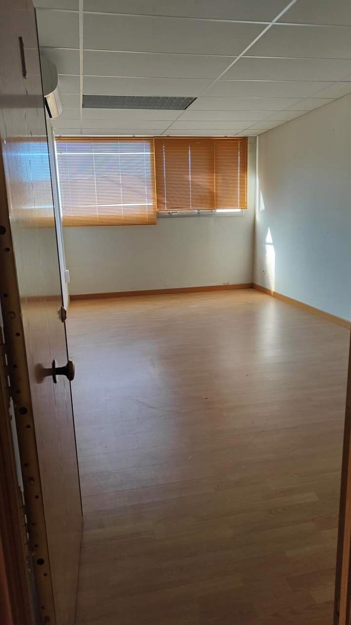 Una habitación vacía con suelo de madera y una ventana.