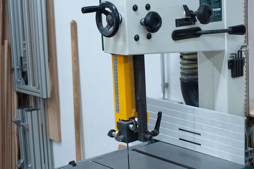 Eine Bandsäge steht auf einem Tisch in einer Werkstatt.