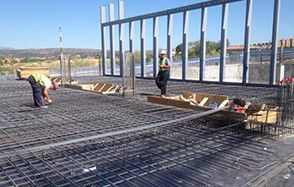Un grupo de trabajadores de la construcción está trabajando en un piso de concreto.