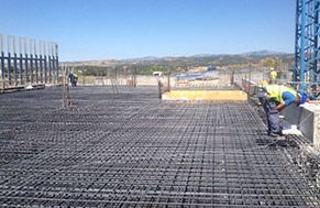 Un grupo de trabajadores de la construcción está trabajando en un piso de concreto.