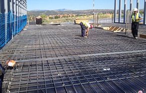 Un grupo de trabajadores de la construcción está trabajando en un piso de concreto.