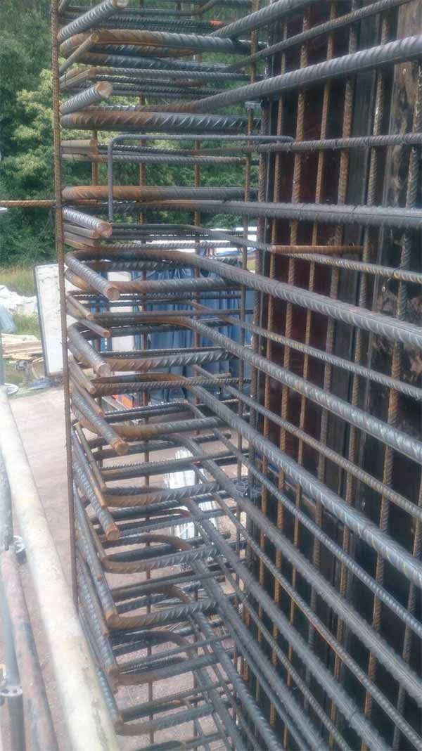 Un montón de barras de metal están apiladas una encima de otra en una pared.