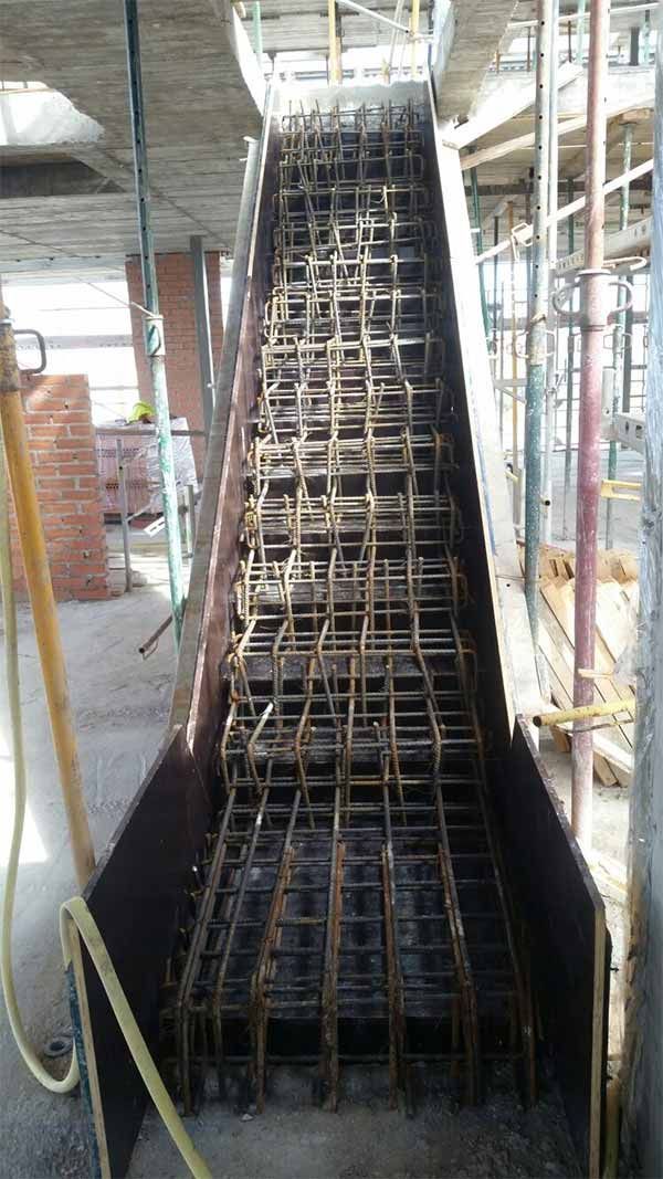 Se está construyendo una escalera metálica en un edificio en construcción.