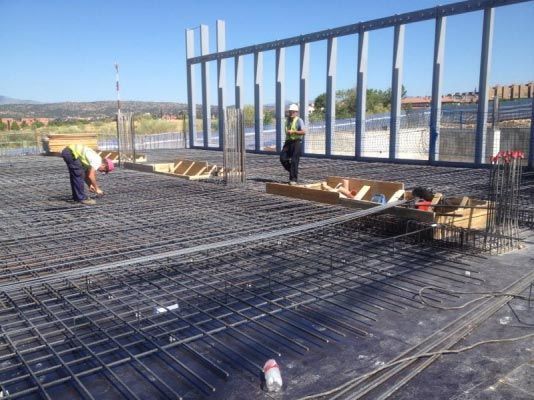 Dos trabajadores de la construcción están trabajando en un piso de concreto.