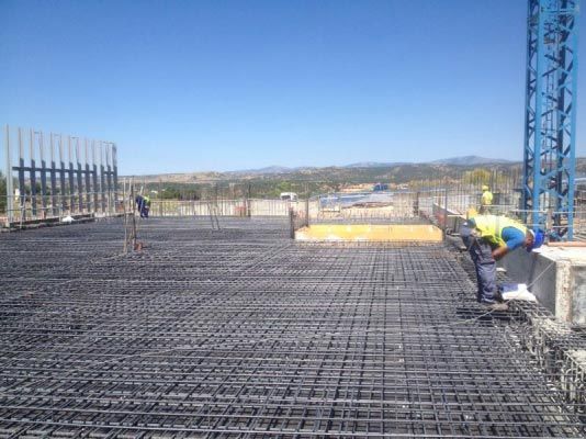Un grupo de trabajadores de la construcción está trabajando en un piso de concreto.