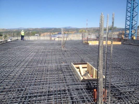 Un hombre con un chaleco amarillo está parado en un sitio de construcción.