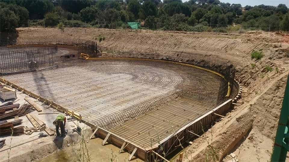 Un hombre está parado en medio de un campo de tierra.