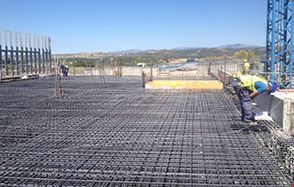 Un grupo de trabajadores de la construcción está trabajando en un piso de concreto.