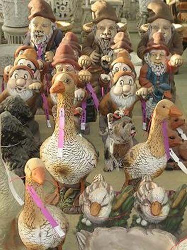 Un grupo de gnomos y patos están sentados uno al lado del otro en una mesa.