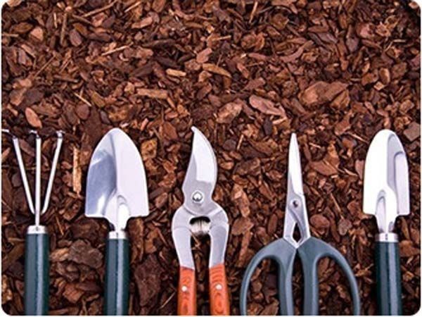 Un montón de herramientas de jardinería sobre una pila de mantillo.