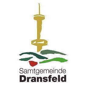 Logo der Samtgemeinde Dransfeld. Es zeigt einen goldenen Turm auf einer grün-roten stilisierten Landschaft. Schwarzer Text darunter.