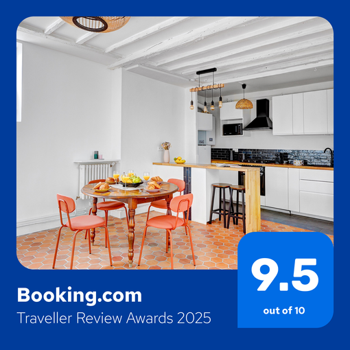 A brightly lit kitchen and dining area with a round table, chairs, and modern appliances. Booking.com rating 9.5 out of 10.