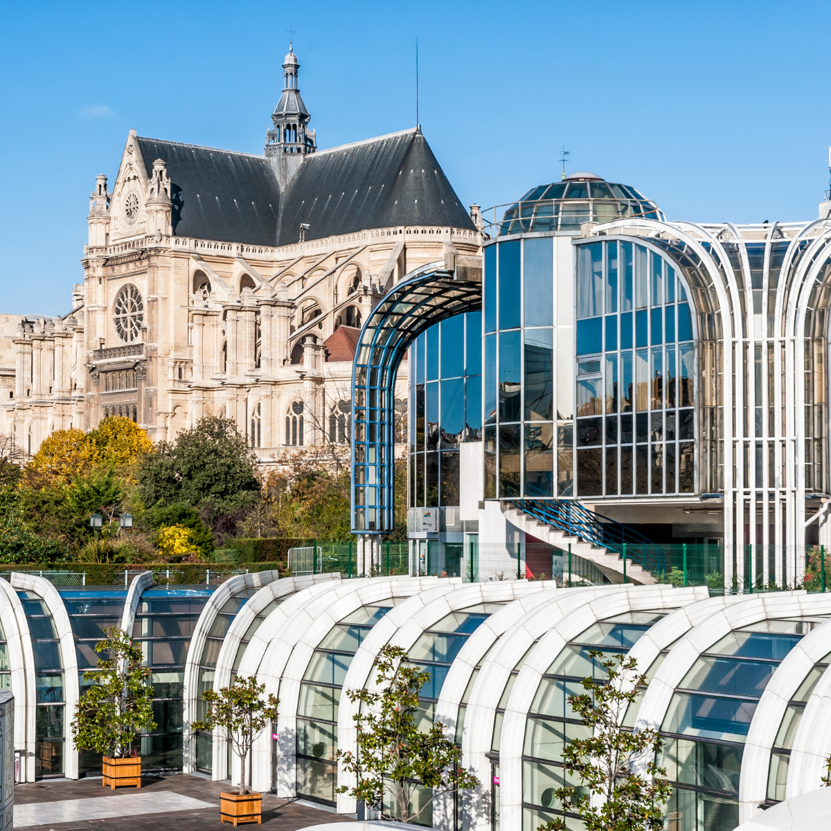 Woman wearing headset at desk with computer, Eiffel Tower art in background.