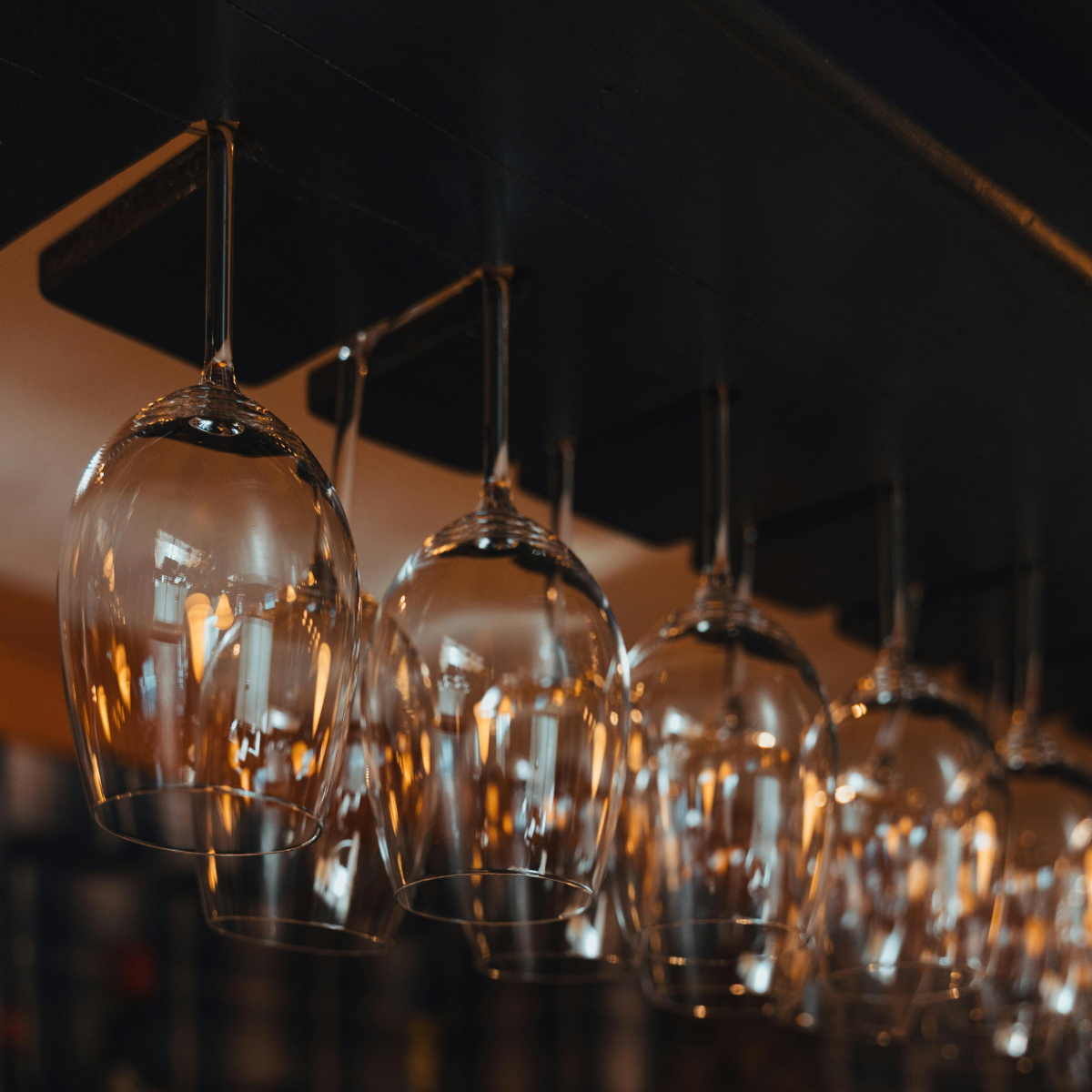 Narrow Parisian street lined with tall, cream-colored buildings. Street slopes downward; pedestrians and shops visible. 