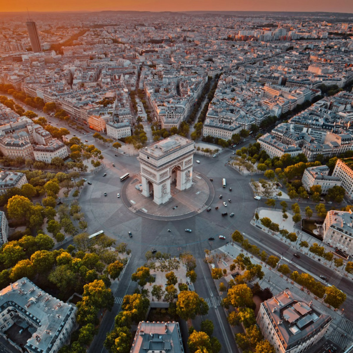 Woman wearing headset at desk with computer, Eiffel Tower art in background.