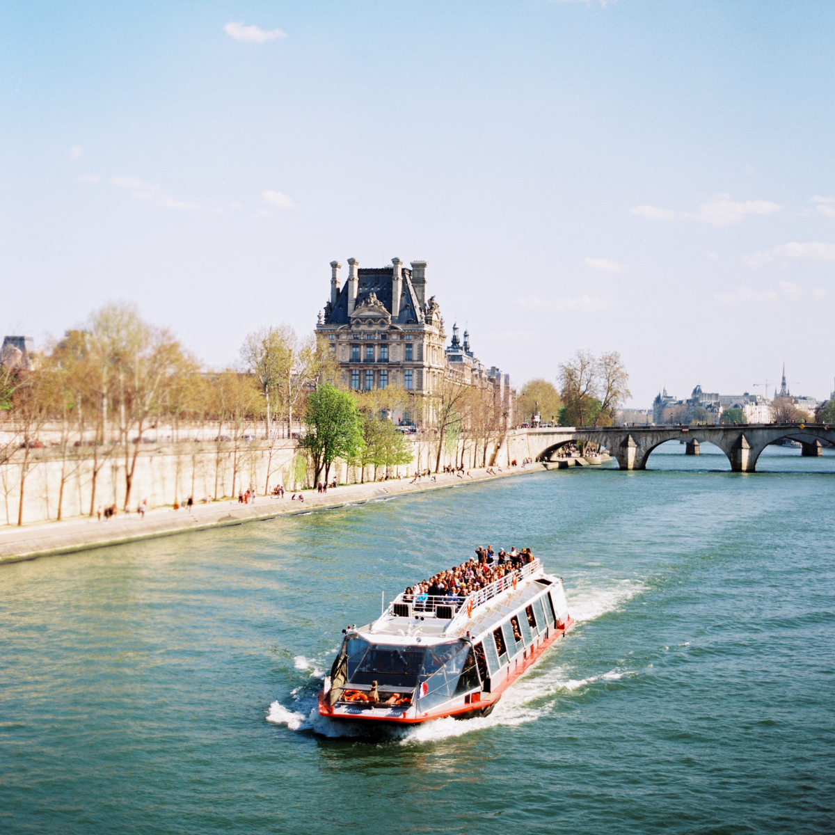 Woman wearing headset at desk with computer, Eiffel Tower art in background.
