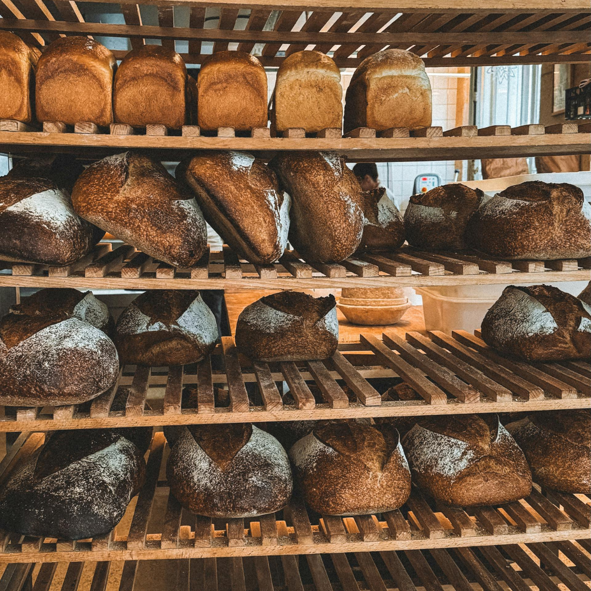 Woman wearing headset at desk with computer, Eiffel Tower art in background.