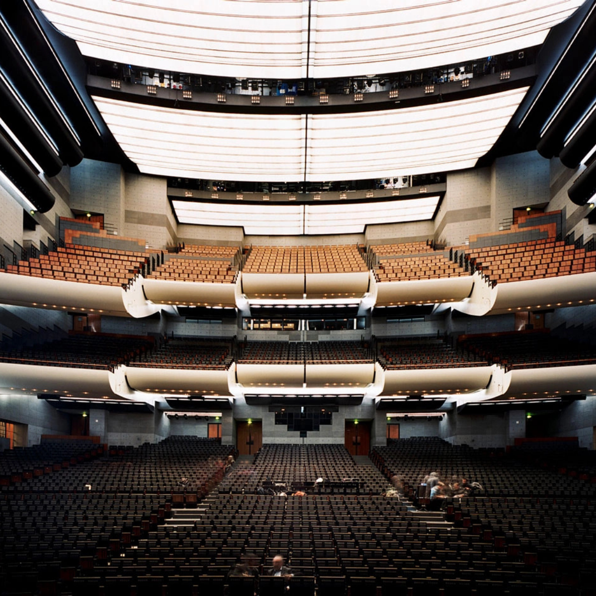 Woman wearing headset at desk with computer, Eiffel Tower art in background.