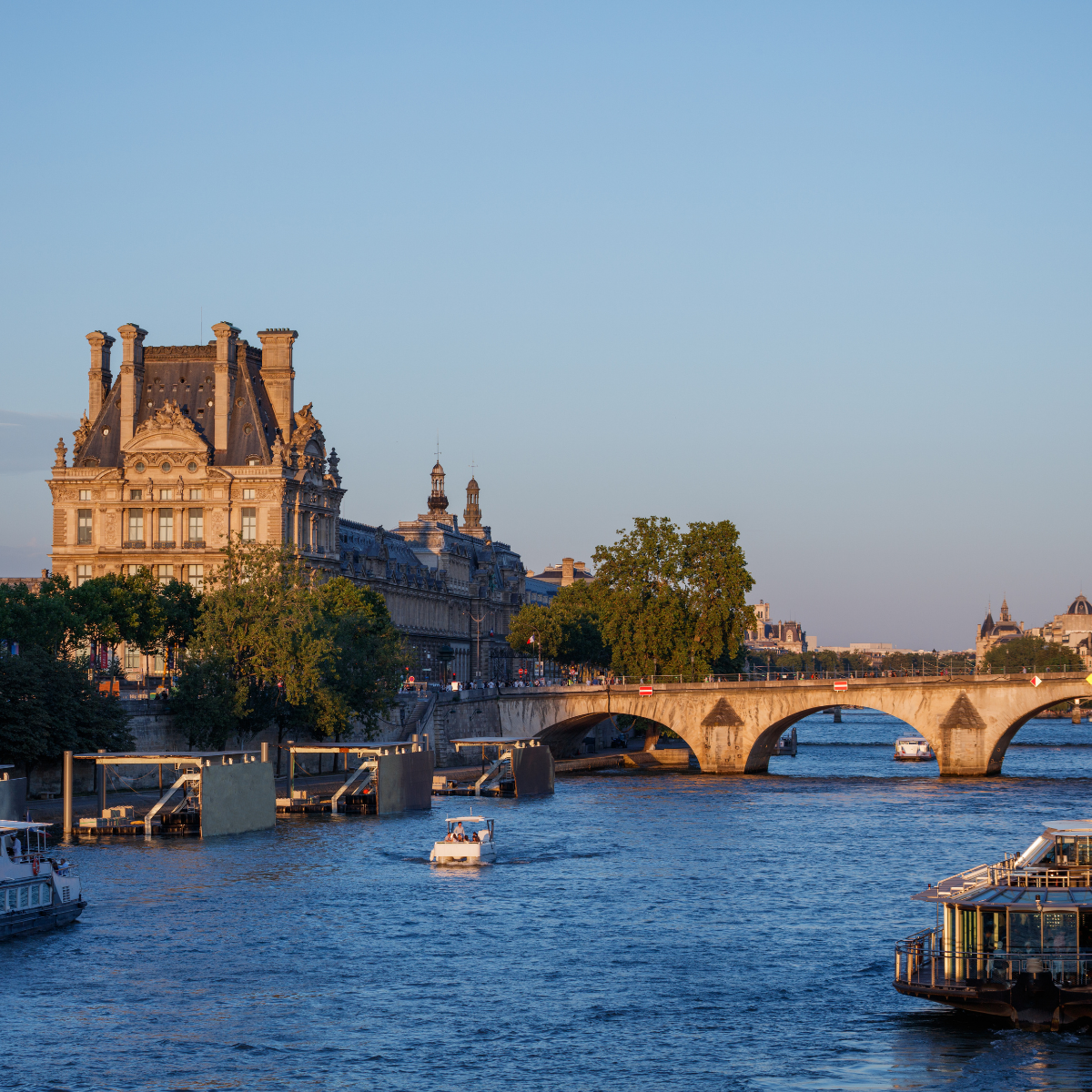 Woman wearing headset at desk with computer, Eiffel Tower art in background.