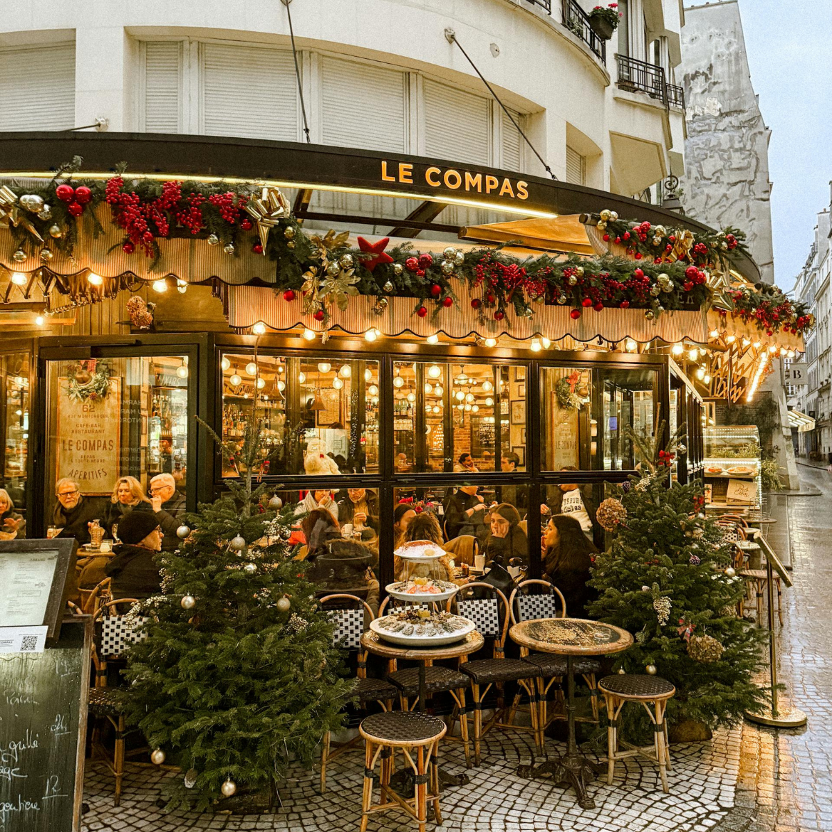 Desk with map, computer screen displaying map, coffee mug, succulent, and window view.