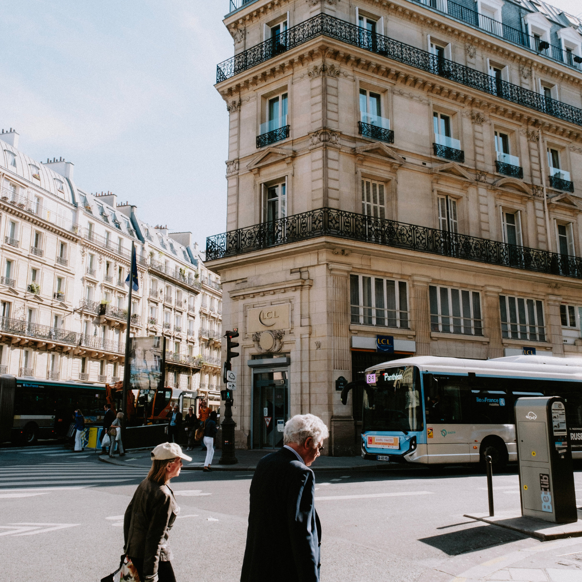 Woman wearing headset at desk with computer, Eiffel Tower art in background.